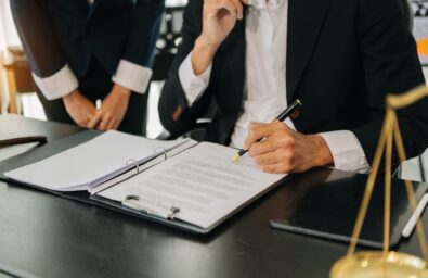 Business and lawyers discussing contract papers with brass scale on desk in office. Law, legal services, advice,  justice and law concept .